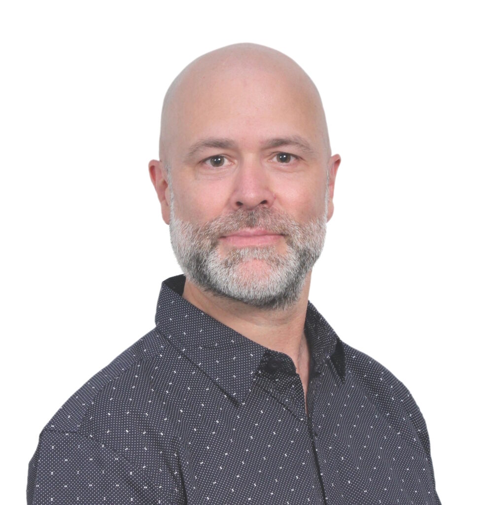 Photo portait de Florian Stäuber, habillé d'une chemise bleue à motifs.